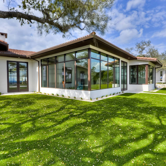 Lawn photo: lush synthetic front yard, tropical plantings